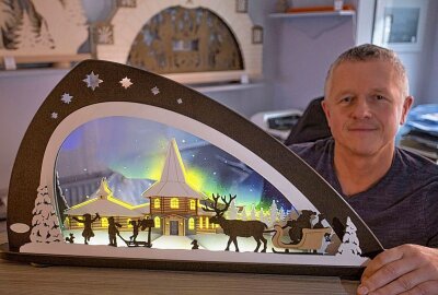 Traditionsfirma aus dem Erzgebirge bannt Naturschauspiel auf Plexiglas - blo_erz: René Weinhold mit dem Polarlichter-Schwibbogen. Der 49-Jährige hat das Exemplar entworfen. Foto: Jan Görner