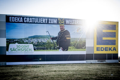 Über 900 Quadratmeter für das frischgebackene Weltkulturerbe -  Das Banner wirbt an der Fassade des Edeka-Zentrallagers an der Autobahnabfahrt Berbersdorf für die Montanregion.