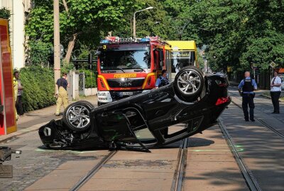Unfall: Audi überschlägt sich und bleibt auf den Gleisen liegen - Die Berufsfeuerwehr (Wachen Striesen und Albertstadt) nahm ausgetretenen Betriebsstoffe auf und drehte den Audi wieder auf die Räder. Foto: Roland Halkasch