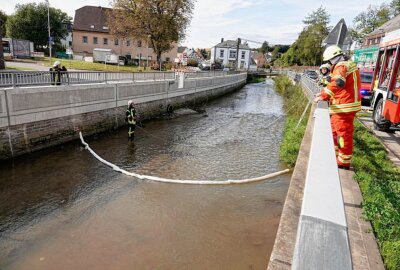 Ungewissheit über verschmutztes Gewässer in Burkhardtsdorf - Die Feuerwehr im Einsatz beim Errichten einer Ölsperre. Foto: Harry Härtel