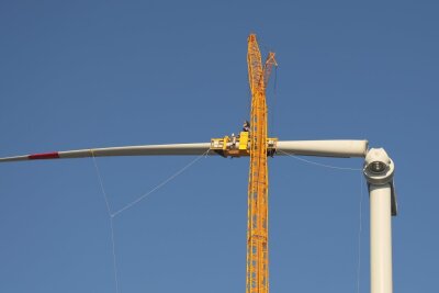 Der erste Flügel wird am "kopflosen" Windrad in Mittelsachsen montiert. Foto: Andrea Funke