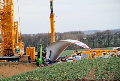 Update: Am bisher "kopflosen" Windrad wird der erste Flügel montiert - 80 Meter langer Windradflügel nach Wiederau transportiert. Foto: Andrea Funke