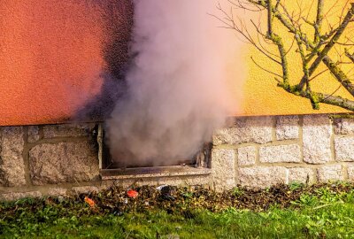Update zu Kellerbrand im Erzgebirge: Polizei ermittelt wegen fahrlässiger Brandstiftung - Der dichte Rauch tritt aus dem Keller. Foto: Andre März