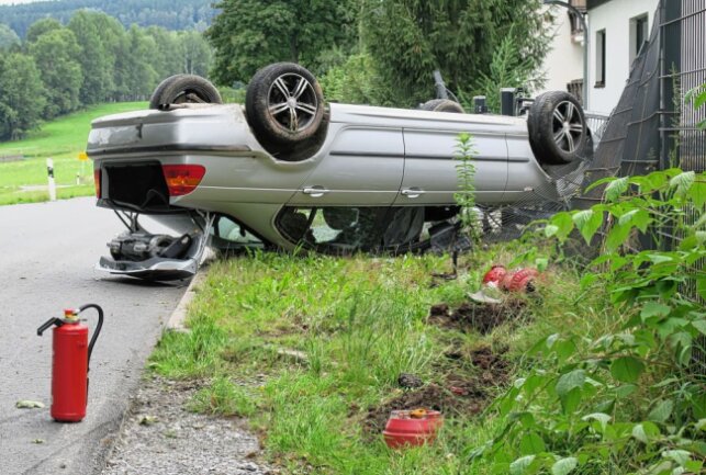 Auf der Grünhainer Straße kam der PKW auf dem Dach zum Liegen. Der Fahrer ist noch flüchtig. Foto: Niko Mutschmann