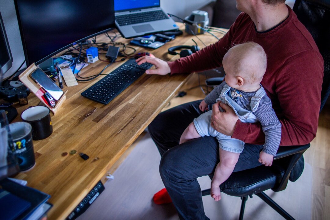 Väter verbringen eineinhalb Stunden mit ihren Kindern - Ein junger Vater im Home-Office mit seinem sechs Monate alten Sohn.