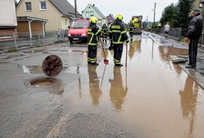 Verkehrsbehinderungen durch starke Unwetter rund um Chemnitz - Feuerwehr und eine Rohrreinigungsfirma sind vor Ort, um einen Gulli auszusaugen. Foto: Harry Härtel