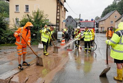 Verkehrsbehinderungen durch starke Unwetter rund um Chemnitz - In Gornsdorf ist die Hauptstraße wegen Überflutung voll gesperrt. Durch das Unwetter wurde auch Schlamm auf die Straße gespült, der jetzt beseitigt wird. Foto: Harry Härtel