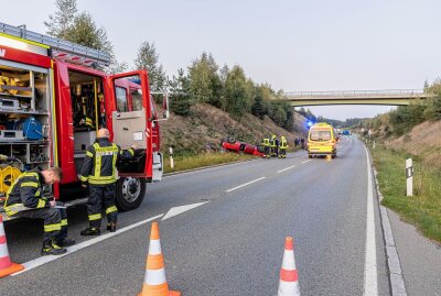 Verkehrsunfall in Treuen: Fahrer verliert die Kontrolle und überschlägt sich - Opel-Fahrer verliert die Kontrolle und überschlägt sich: Ersthelfer kümmern sich um den Verletzten. Foto: B&S/David Rötzschke