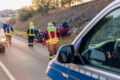 Verkehrsunfall in Treuen: Fahrer verliert die Kontrolle und überschlägt sich - Opel-Fahrer verliert die Kontrolle und überschlägt sich: Ersthelfer kümmern sich um den Verletzten. Foto: B&S/David Rötzschke