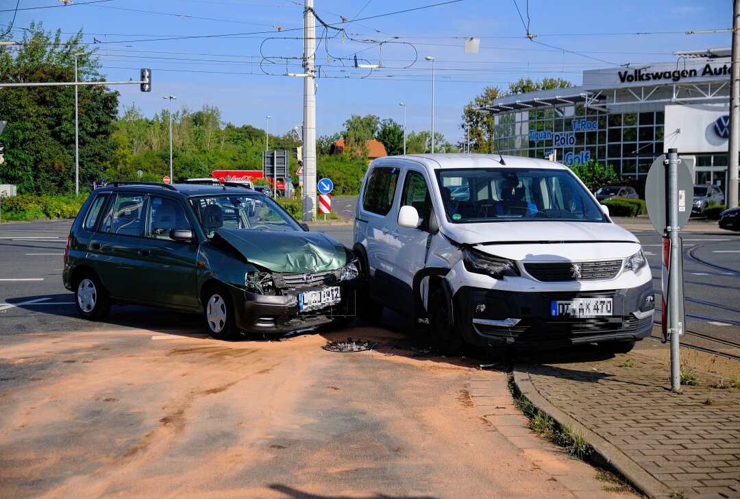 Verletzte Person und beschädigte Ampel nach Kollision zweier Fahrzeuge - In Leipzig kam es zu einem Unfall an einem Kreuzung. Foto: Christian Grube