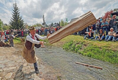 Volksfeststimmung beim Schauflößen in Muldenberg - Mit viel Schwung warfen die Flößer die Holzscheite in den Graben. Foto: Thomas Voigt