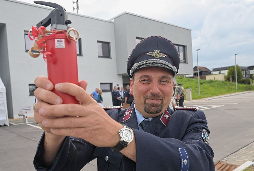 Andreas Fugmann, Ortswehrleiter der Freiwilligen Feuerwehr Stützengrün ist froh über das neue Depot - zur Einweihung gab es symbolisch auch diesen Feuerlöscher. Foto: Ralf Wendland