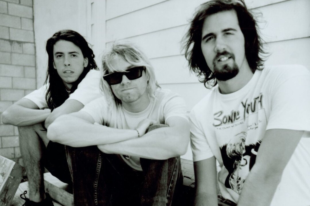 Vor 30 Jahren: Was geschah in den letzten Stunden von Kurt Cobain? - Dave Grohl (links), Kurt Cobain (Mitte) und Krist Novoselić machten mit Nirvana ein ganzes Musikgenre populär: Grunge. Die Geschichte der Band endete vor genau 30 Jahren, als Kurt Cobain tot aufgefunden wurde. Bis heute halten manche die Umstände seines Ablebens für rätselhaft.