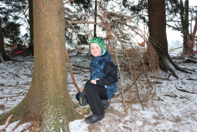 Unmittelbar an der Hütte lockt der Wald mit seinen natürlichen Schätzen die Mädchen und Jungen zum Spielen. Jonas will eine Behausung aus Zweigen bauen.