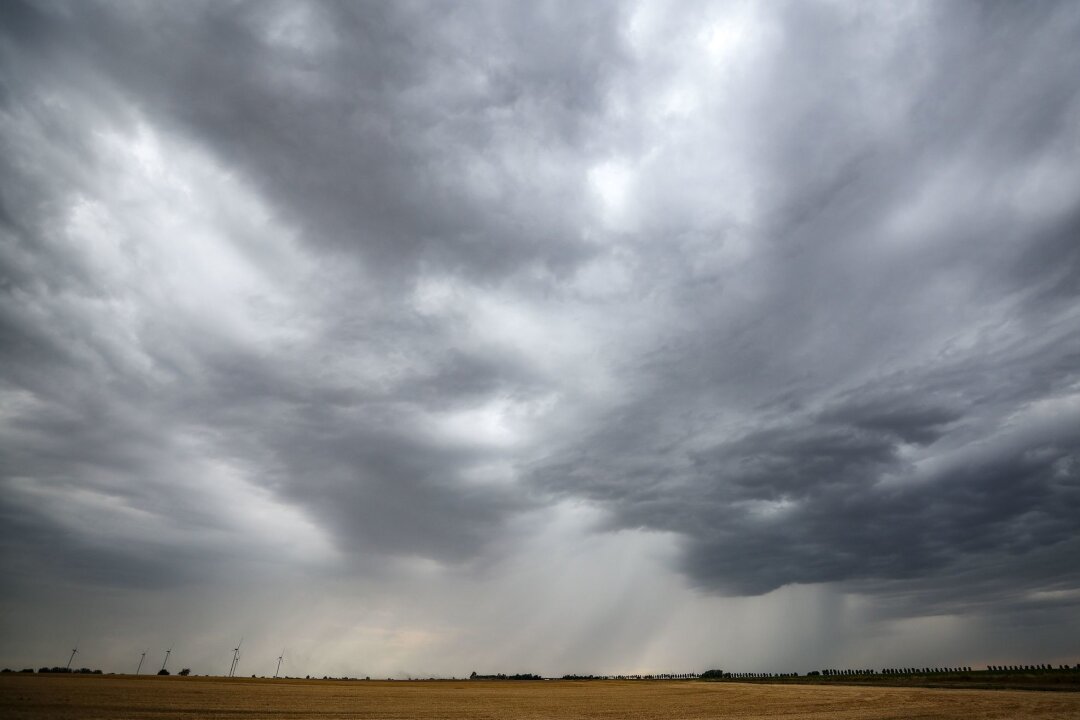 Warnung: Gewittern in Ostsachsen und Sächsischer Schweiz - Eine Regenfront zieht über ein Getreidefeld hinweg.
