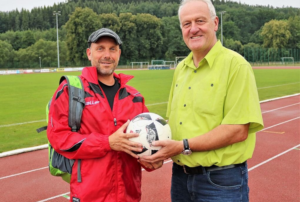 Warum ein Fußball-Fan aus Mittelsachsen mehr als 1000 Kilometer für seinen Verein lief - Andre Schäfer wurde von Amand-Prokurist Torsten Rölig beglückwünscht. Foto: Knut Berger