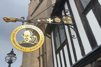 Was man von Shakespeare heute noch lernen kann - Ein Schild an einem historischen Gebäude (Guildhall) in Stratford-upon-Avon erinnert an William Shakespeare.