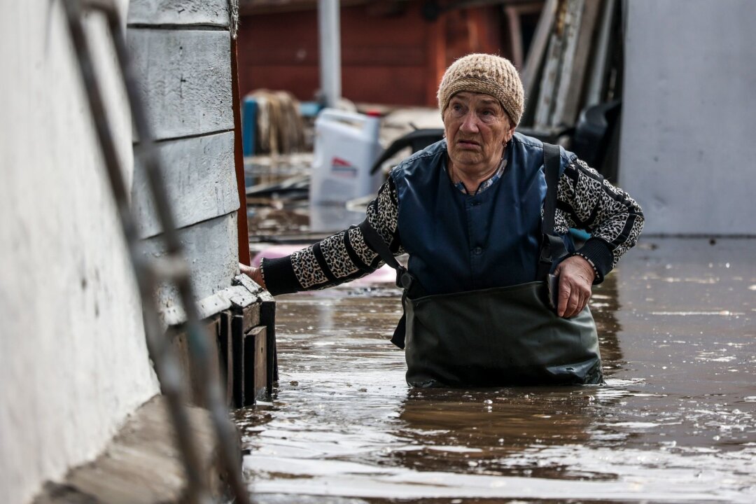 Wasser in russischem Flutgebiet steigt weiter stark an - Eine Frau in der Nähe ihres Hauses in einem überschwemmten Gebiet in Orenburg, Russland.
