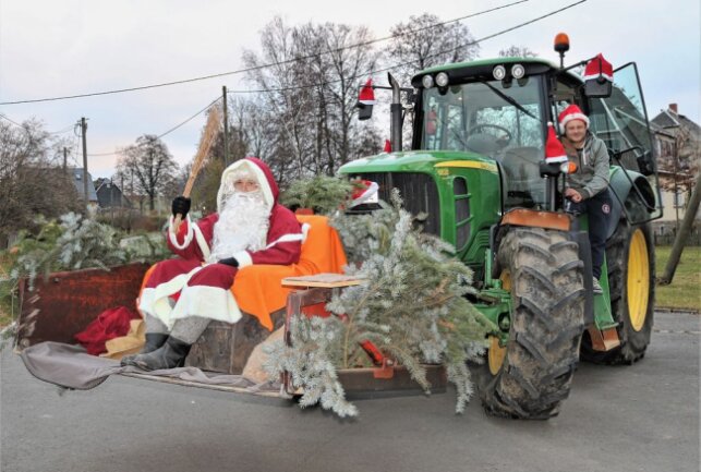 Der Weihnachtsmann wird auch in diesem Jahr von Kleinhartmannsdorfer Ortsvorsteher Marcel Möckel (r.) per Traktor durch den Ort gefahren. Foto: Knut Berger