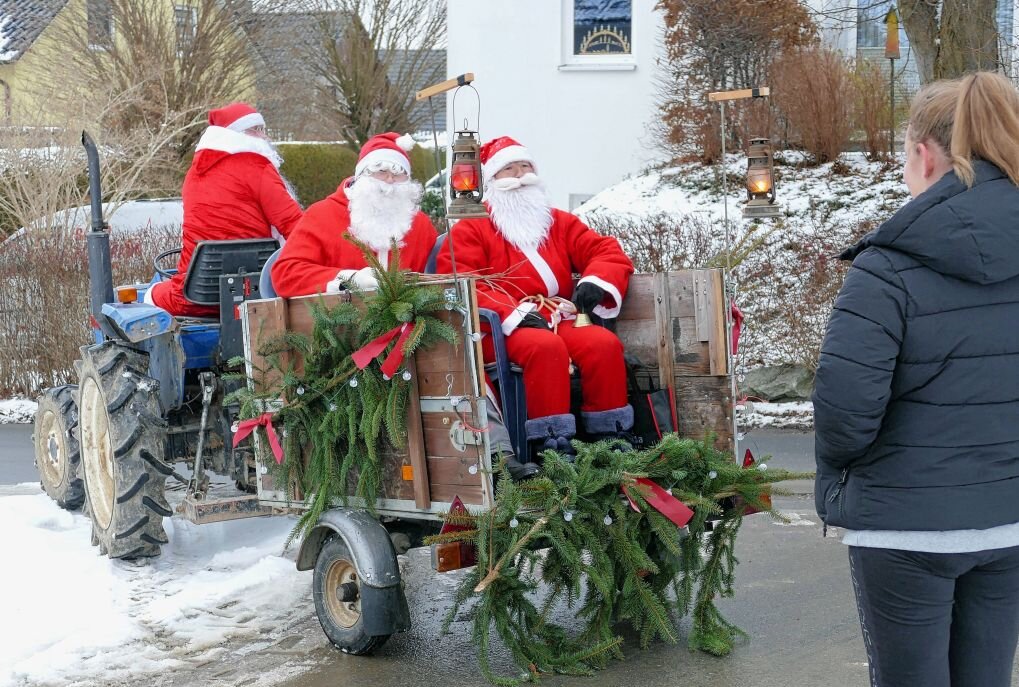 Im Amtsberger Ortsteil Schlösschen waren gleich drei Weihnachtsmänner gemeinsam auf Tour. Foto: Andreas Bauer