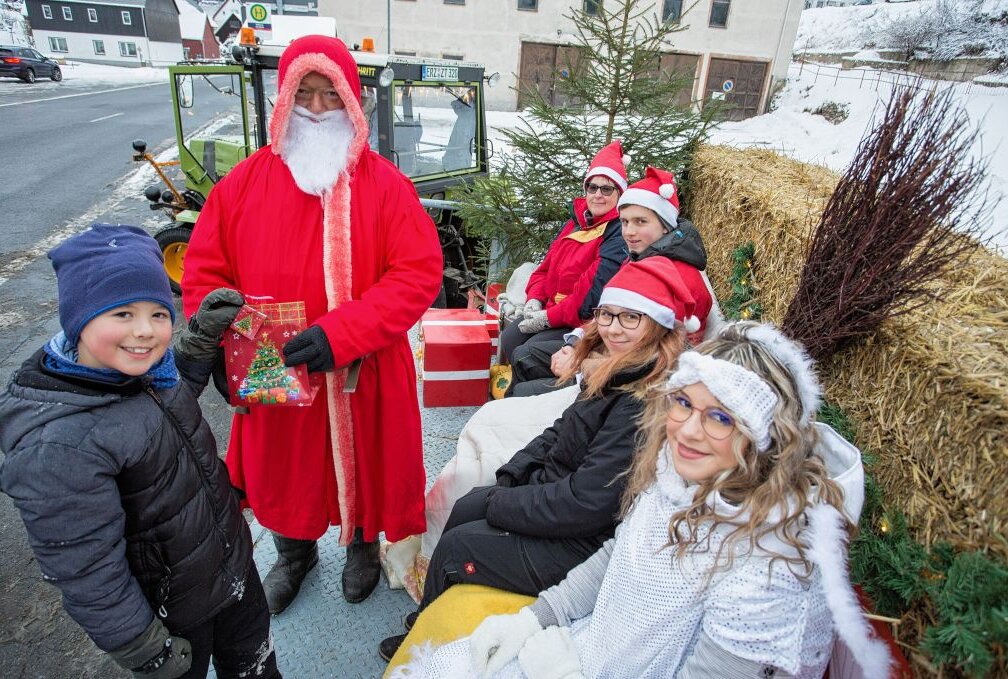 Weihnachtsmann verteilt Geschenke in Rübenau - Phil Steinert hat den Weihnachtsmann Sandro Rothe, Anja Hänel, Florian Kirchner, Jasmin Hänel und Jenny Dittrich (v.l.) auf dem Weihnachtsmann-Anhänger besucht. Foto: Jan Görner