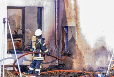 Werkstatt in Großrückerswalde ausgebrannt - Ein Feuerwehrmann bei der Arbeit. André März