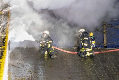 Werkstatt in Großrückerswalde ausgebrannt - Löschen der Flammen vom Dach aus mit Atemschutzmasken. Foto: André März