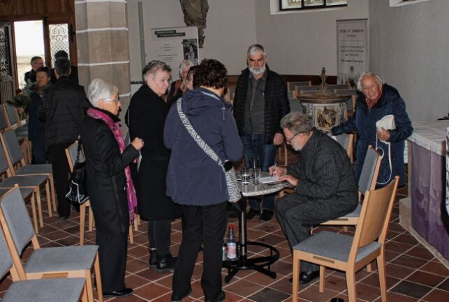 Wie ein Chemnitzer Künstler den Altar im Freiberger Dom verhüllte - Michael Morgner beim Signieren des Programmheftes Foto: Renate Fischer