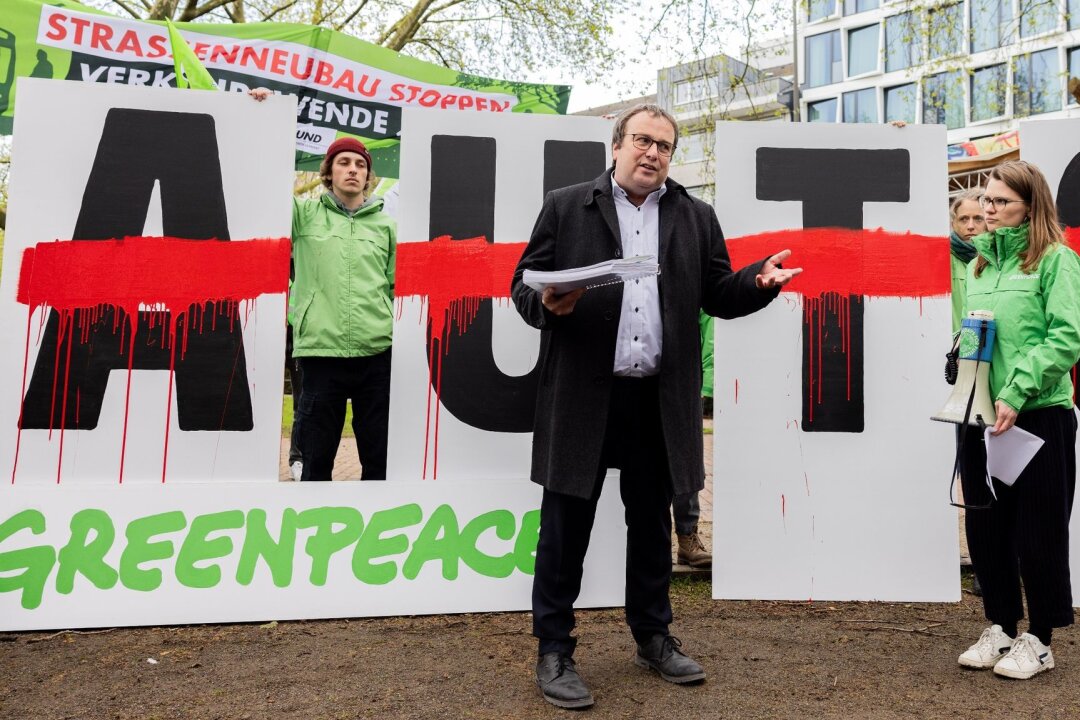 Wie geht es weiter mit dem Deutschlandticket? - Aktivisten von Greenpeace übergeben eine Petition an den NRW-Verkehrsminister Oliver Krischer (Bündnis 90/Die Grünen).