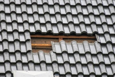 Wind weht Dachziegel von Wohnhaus in Aue-Bad Schlema - Der Schaden aus der Nähe betrachtet. Foto: Niko Mutschmann