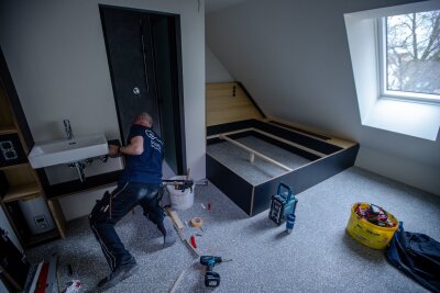 Wismar: Im "Kittchen" sind bald Zimmer frei - Handwerker bauen die ersten massgefertigten Hotelmöbel in einem der Zimmer in der ehemalige Jugend-Arrestanstalt ein.