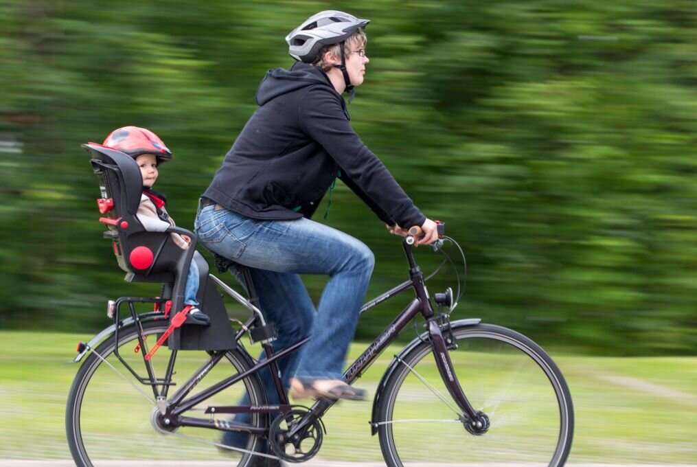 Worauf bei Fahrradsitzen für Kinder zu achten ist - Vorbildlich radeln: Mit passendem Kindersitz - und nicht nur der Nachwuchs trägt Helm.