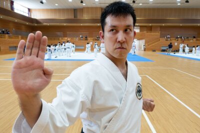 Ziegel, Ton und Plastik bricht: In der Urheimat des Karate - Meister seines Fachs: Zenei Shimabukuro trägt einen schwarzen Gürtel und macht vor, wie eine Verteidigungsstellung im Karate auszusehen hat.