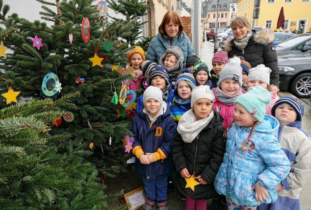 Als erste haben die Kinder aus der Kita "Pfiffikus" ihre Basteleien an den Weihnachtsbäumen in der Zschopauer Innenstadt angebracht. Foto: Andreas Bauer