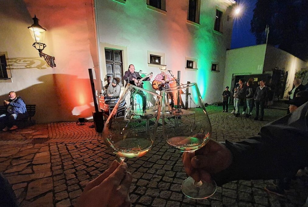 Zschopauer Weinfest übertrifft alle Erwartungen - Bei Live-Musik stießen im Hof von Schloss Wildeck zahlreiche Besucher mit ihren Weingläsern an. Foto: Andreas Bauer