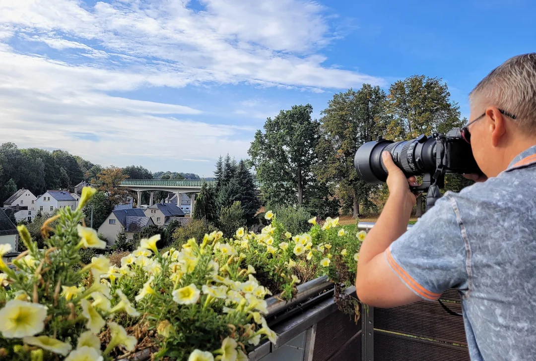 Zu Besuch beim Hobbyfotografen in Lichtenau - Schon seit seiner Jugend fotografiert der 50-Jährige Lichtenauer leidenschaftlich gern. Hier steht er auf seinem Balkon in Ottendorf, den Fokus auf den sogenannten Überflieger gerichtet.