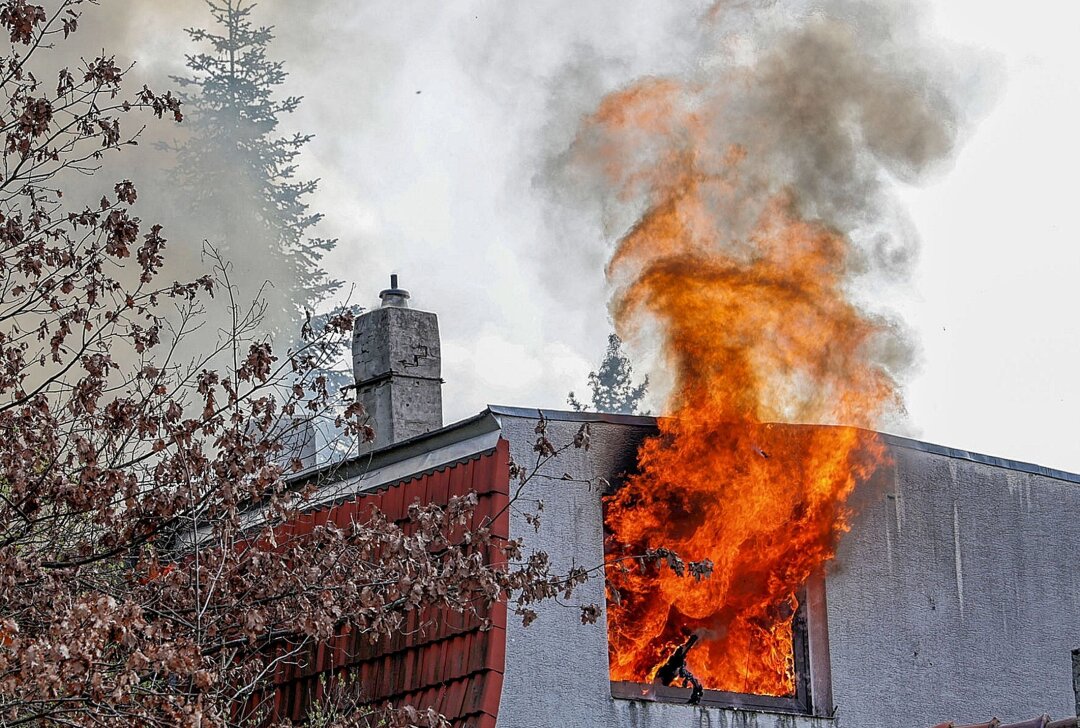 Zwei Verletzte bei Brand: Meterhohe Flammen steigen aus Wohnhaus - Die Feuerwehr arbeitet auf Hochtouren. Foto: Andreas Kretschel