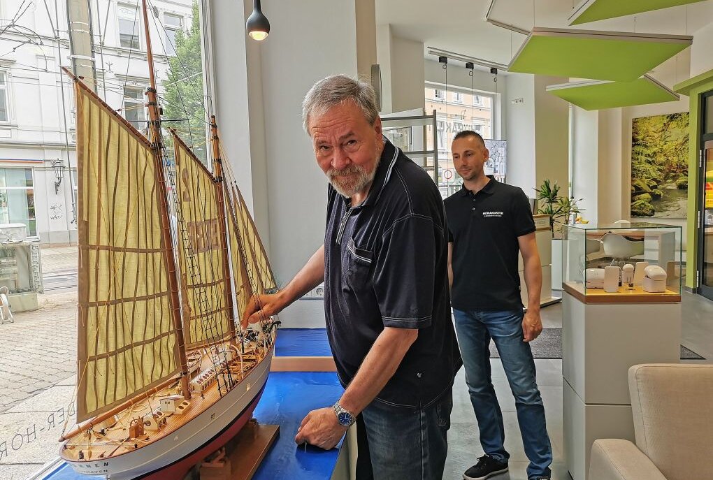 Hörakustiker Ralf Käseberg (r) ist begeistert von dem Werk des Schiffsmodellbauers Manfred Fähnrich. Foto: Ludmila Thiele